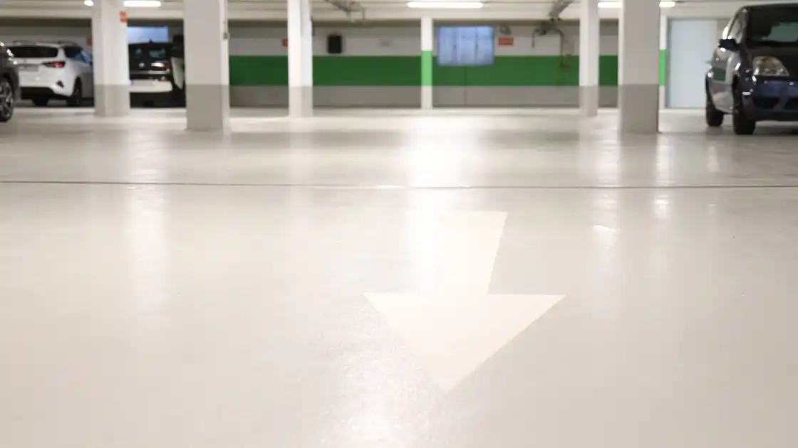 Eine Tiefgarage mit einem weißen Pfeil auf dem Boden